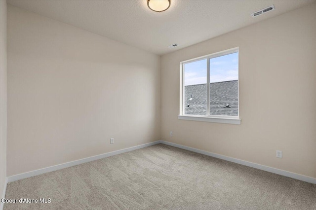 spare room featuring visible vents, baseboards, and carpet flooring