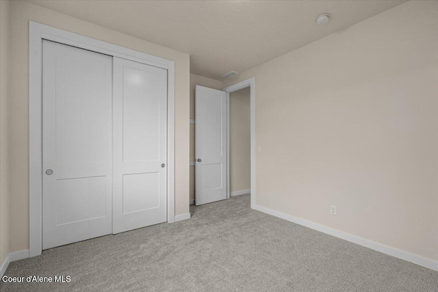 unfurnished bedroom with a closet, baseboards, and carpet floors