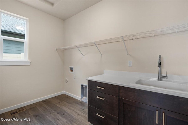 laundry room with visible vents, baseboards, washer hookup, cabinet space, and a sink