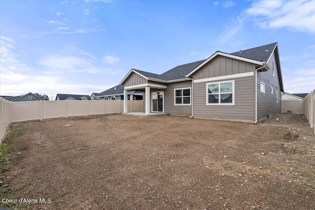 back of house with a fenced backyard and board and batten siding