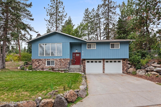 split foyer home featuring a front lawn, concrete driveway, stone siding, and an attached garage