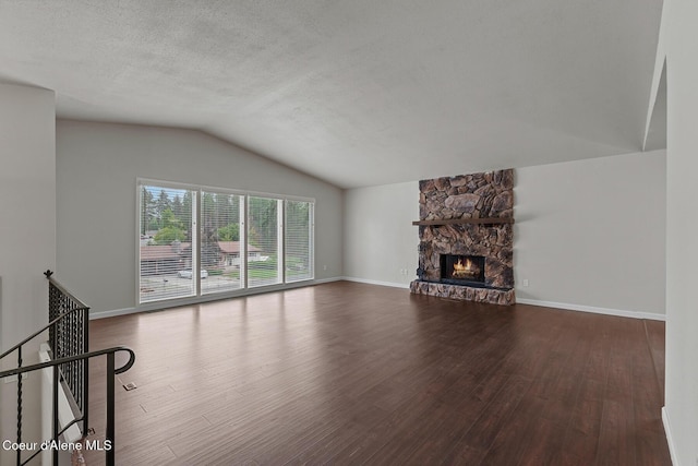 unfurnished living room featuring a textured ceiling, wood finished floors, a fireplace, and vaulted ceiling