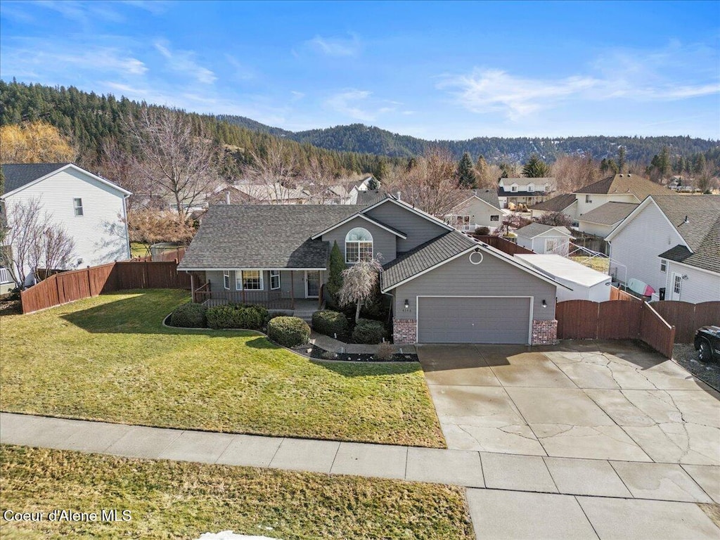 view of front of house with a front yard, an attached garage, fence, and brick siding