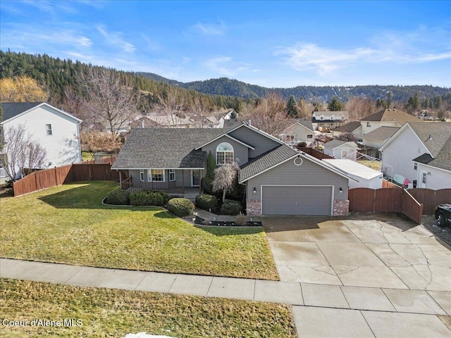 view of front of house with a front yard, an attached garage, fence, and brick siding