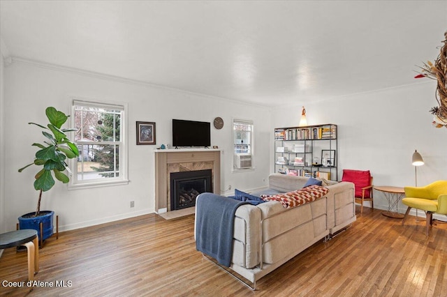 living room with a high end fireplace, plenty of natural light, light wood-type flooring, and baseboards