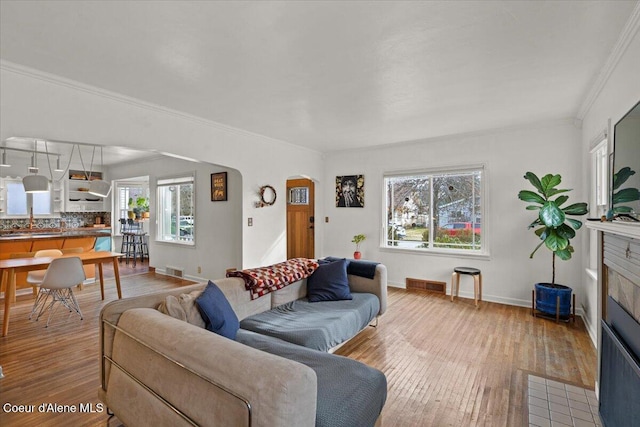 living area with a wealth of natural light, arched walkways, and wood finished floors