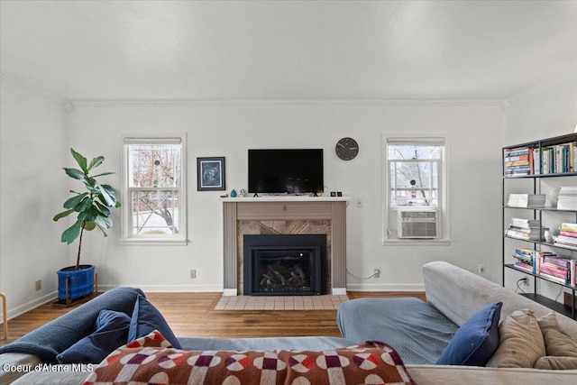 living area featuring plenty of natural light, wood finished floors, and ornamental molding