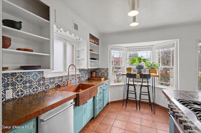 kitchen featuring open shelves, a sink, appliances with stainless steel finishes, dark countertops, and backsplash