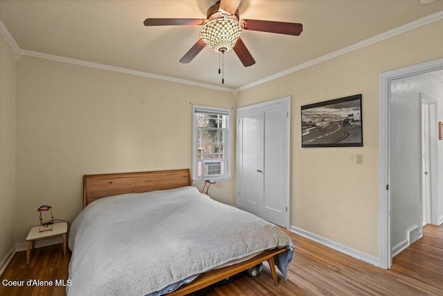 bedroom with ornamental molding, baseboards, and wood finished floors