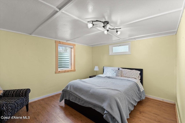 bedroom featuring wood finished floors and baseboards