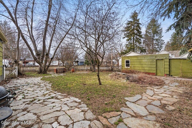 view of yard featuring an outdoor structure and fence