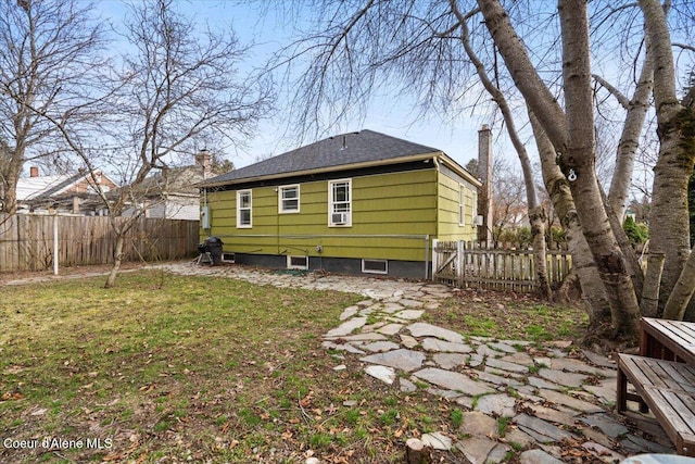 back of house featuring cooling unit, a lawn, a fenced backyard, and a chimney