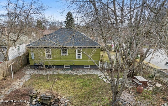 back of house featuring a fenced backyard and a lawn