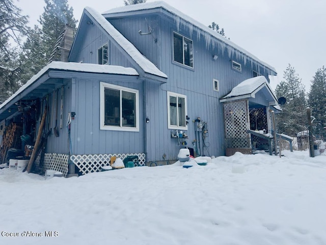 view of snow covered rear of property