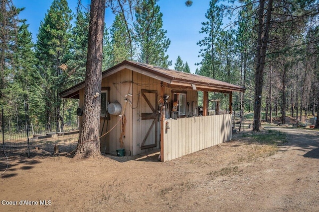 view of outdoor structure with an outbuilding and fence