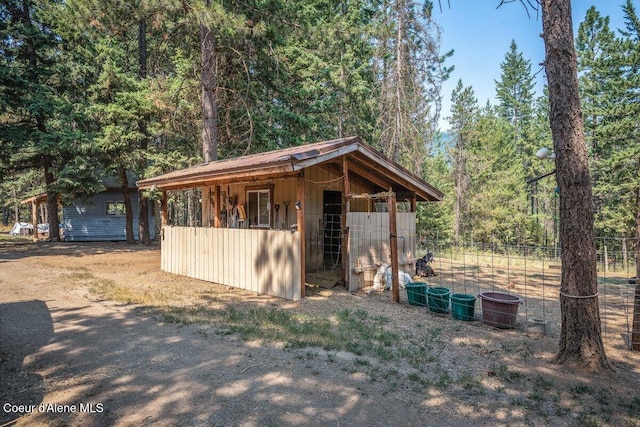 view of outbuilding with an exterior structure, a forest view, and an outdoor structure