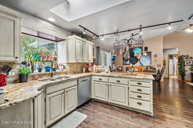 kitchen featuring a sink, stainless steel dishwasher, dark wood-style floors, a peninsula, and vaulted ceiling