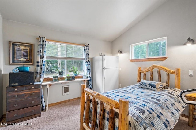 bedroom with baseboards, lofted ceiling, light carpet, and freestanding refrigerator