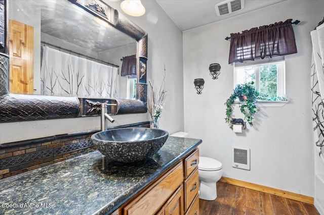 bathroom featuring vanity, wood finished floors, visible vents, baseboards, and toilet