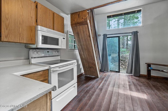 kitchen with white appliances, dark wood-type flooring, brown cabinetry, and light countertops