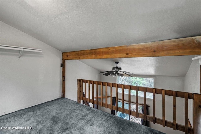 interior space with vaulted ceiling with beams, a ceiling fan, carpet floors, and a textured ceiling