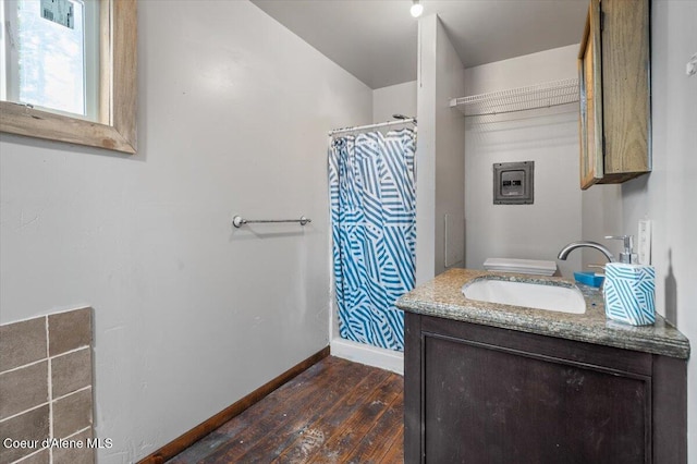 full bath with a shower with curtain, vanity, baseboards, and hardwood / wood-style floors