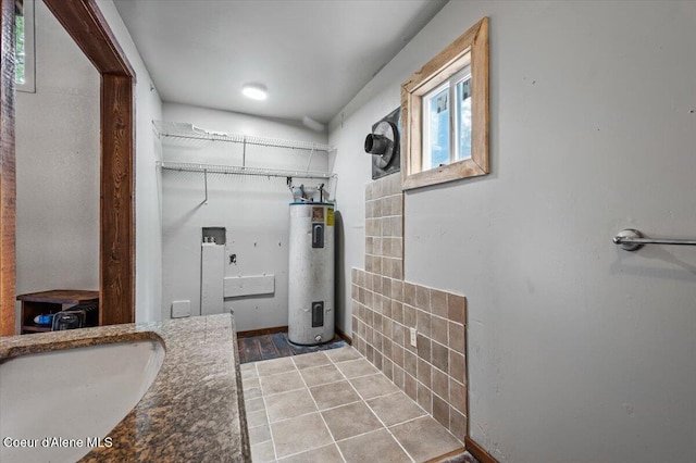 bathroom featuring water heater, tile patterned flooring, and a sink