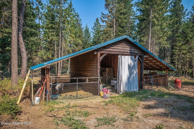 view of outbuilding featuring an outbuilding, an exterior structure, and a wooded view