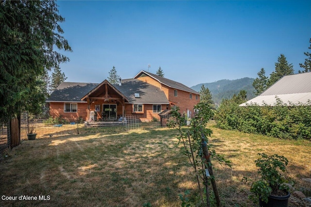 view of front of home featuring a front yard, fence, and a mountain view