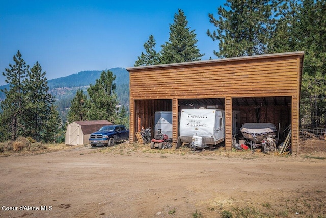 view of shed with a mountain view and dirt driveway