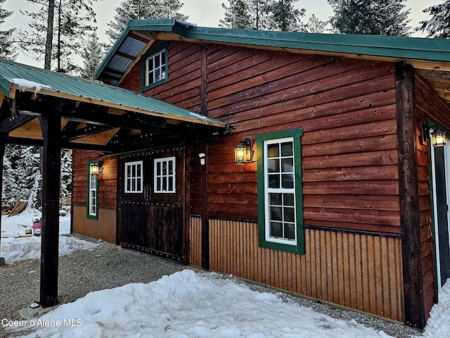 snow covered property featuring metal roof