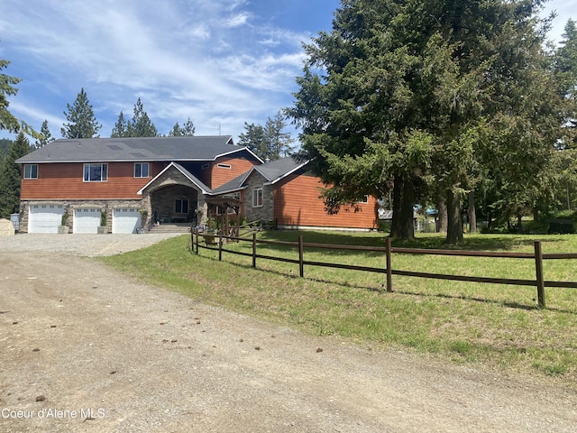 view of front of home with dirt driveway, a front lawn, a garage, and fence