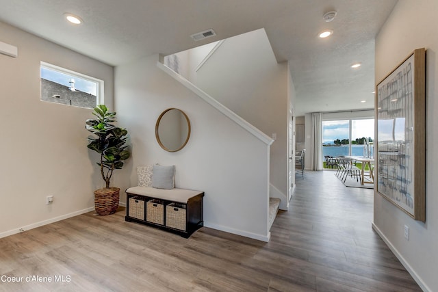 355 E Burdock Loop, Hayden, ID 83835 - hallway featuring visible vents, baseboards, wood finished floors, and stairway