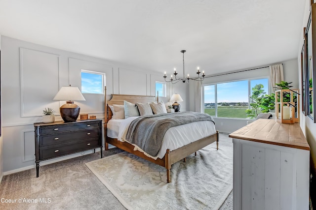 355 E Burdock Loop, Hayden, ID 83835 - bedroom with light colored carpet, a notable chandelier, and a decorative wall