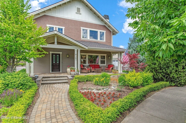 view of front of property with board and batten siding, covered porch, and a chimney