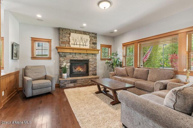 living room with recessed lighting, dark wood finished floors, and a fireplace