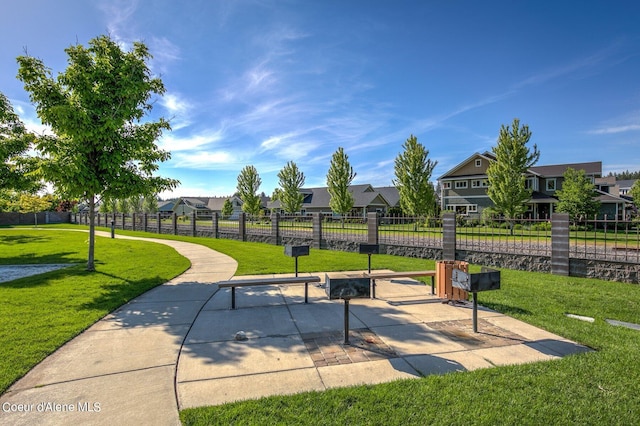 view of home's community featuring fence, a lawn, and a residential view