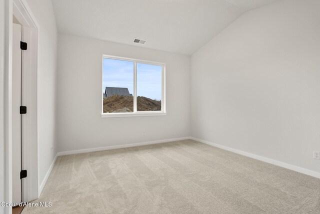 carpeted empty room featuring lofted ceiling, baseboards, and visible vents