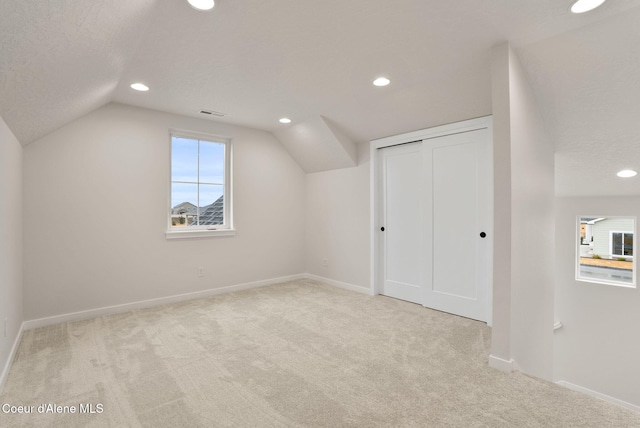 additional living space featuring carpet floors, baseboards, and vaulted ceiling