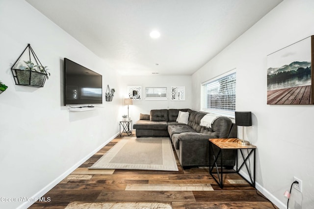 living area featuring baseboards and dark wood-style flooring