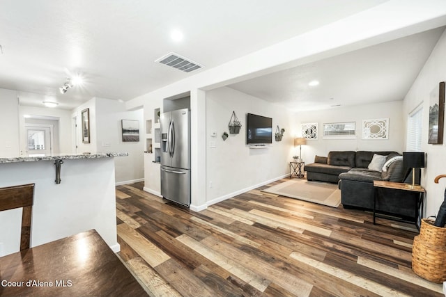 living area with visible vents, baseboards, and dark wood-type flooring