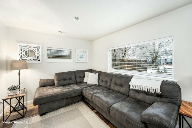 living room featuring visible vents, baseboards, and wood finished floors