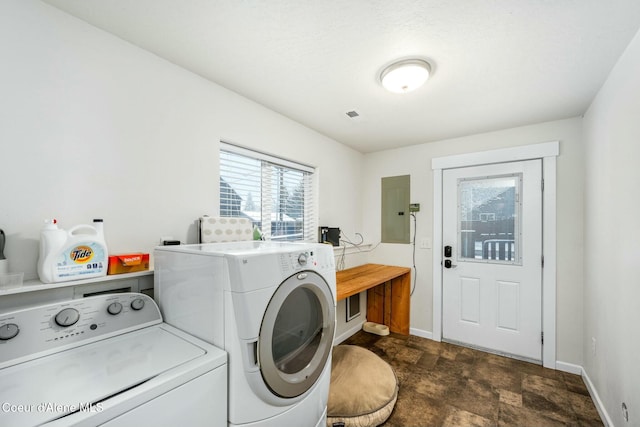 washroom featuring electric panel, laundry area, baseboards, and washing machine and clothes dryer