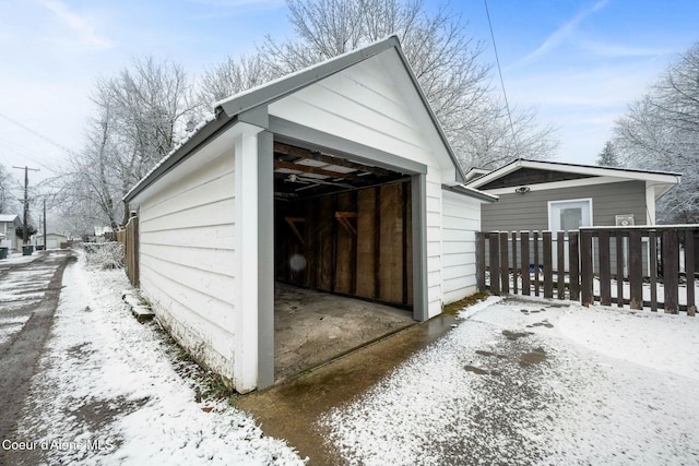 snow covered garage featuring a detached garage