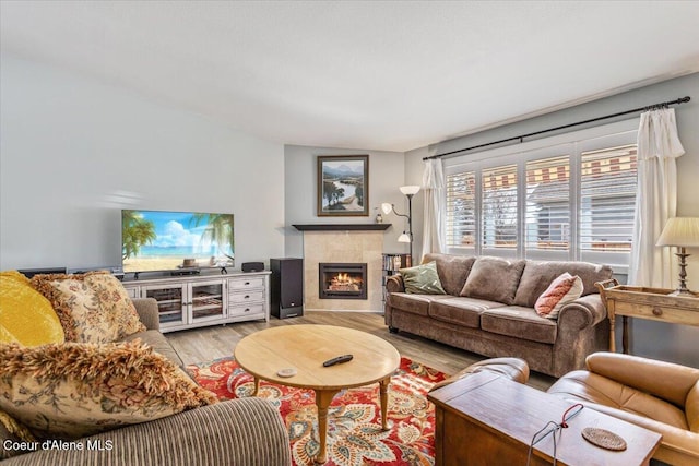 living room featuring wood finished floors and a tiled fireplace