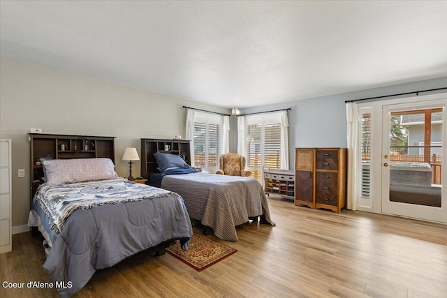 bedroom with access to outside and light wood finished floors