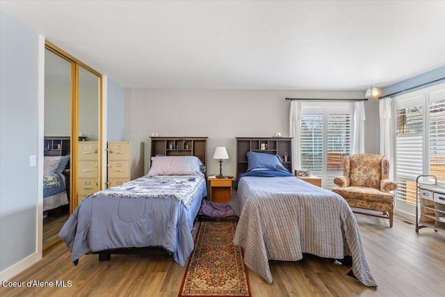 bedroom with baseboards and wood finished floors