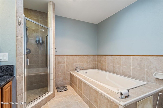 bathroom with a shower stall, a garden tub, and tile patterned floors