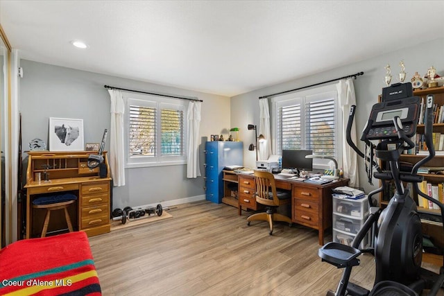 office area with recessed lighting, light wood-type flooring, plenty of natural light, and baseboards