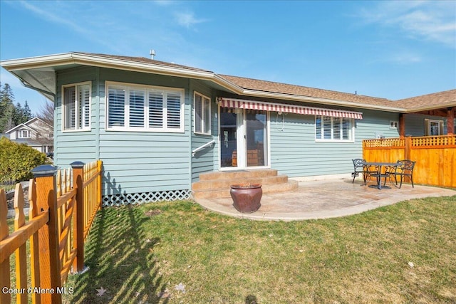 back of property with a yard, entry steps, a fenced backyard, and a patio area